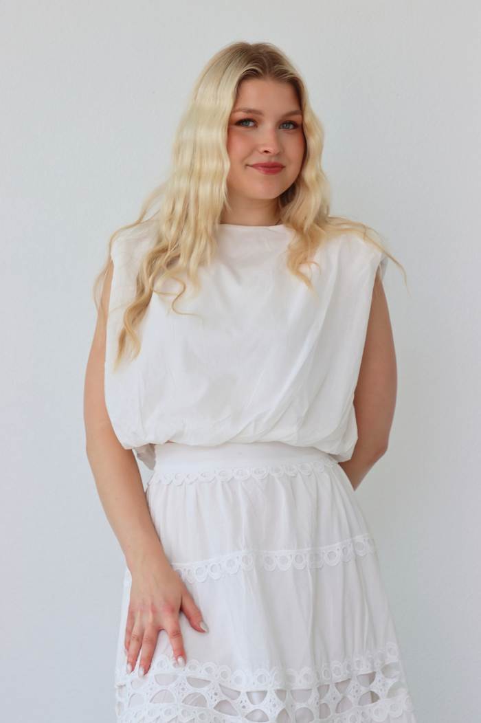 girl wearing matching white set; long skirt and tank top