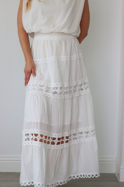 girl wearing matching white set; long skirt and tank top
