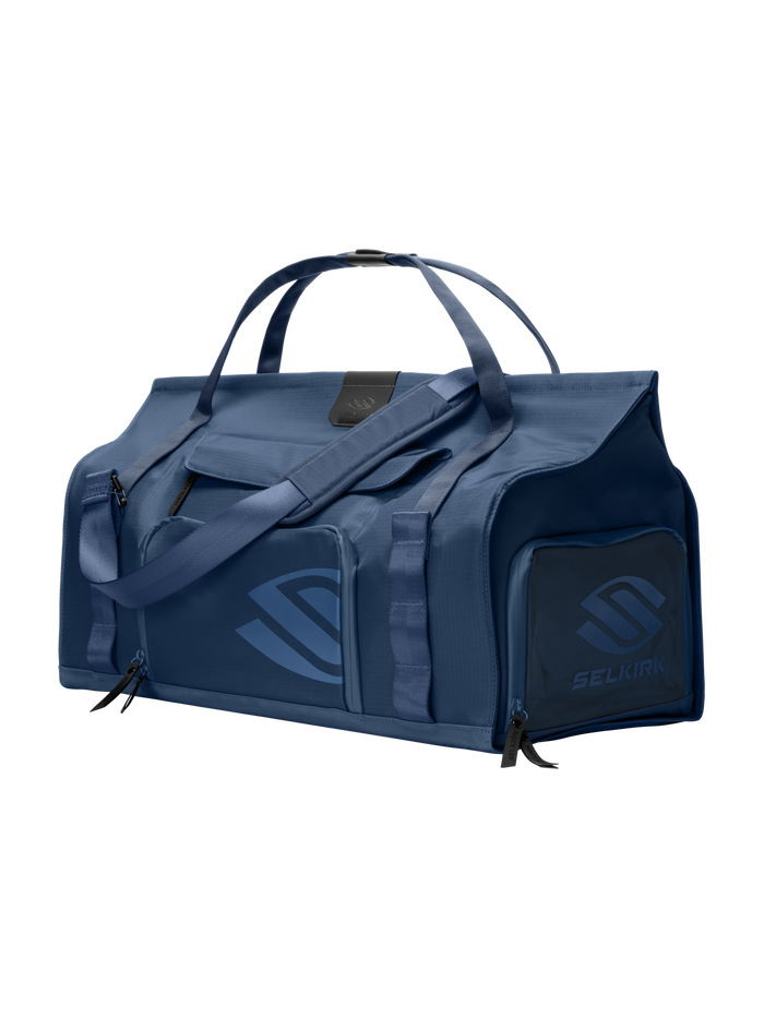 Front-right view of Selkirk Pro Line 2.0 duffel bag with top handles, padded shoulder strap and exterior zip pockets on dark background