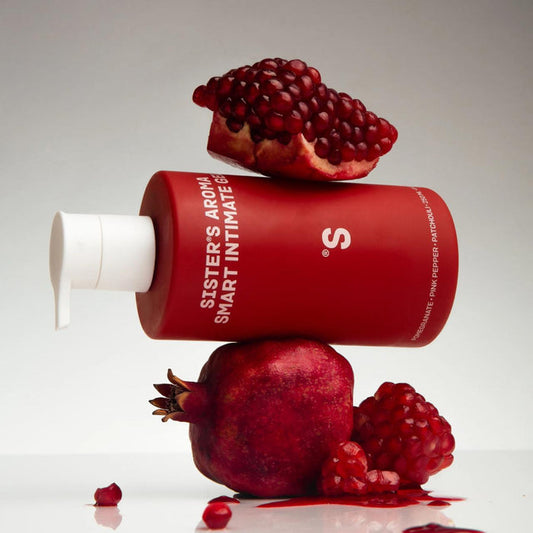 sister's aroma intimate gel pomegranate surrounded by pomegranates on a light gray background