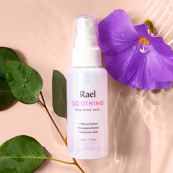 Rael Soothing Feminine Mist on a water background with a purple flower.