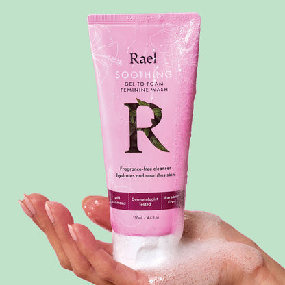 A hand holding a pink tube of Rael Soothing Vulva Care Gel-to-Foam Feminine Wash.