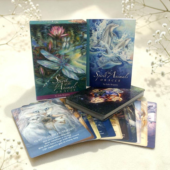 Collection of 'Spirit of the Animal Oracle' cards on a light background with flowers.