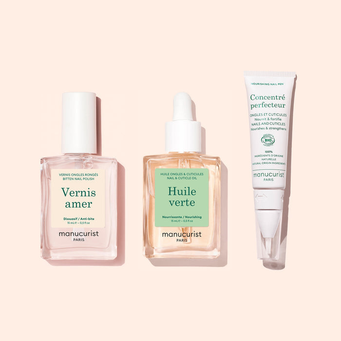 The Manucurist Starter Routine - Bitten Nails set—featuring a pink nail polish, a dropper bottle of nail and cuticle oil, and a nail treatment cream in a white tube on a pale pink background—is designed to support nail regrowth and restore beauty to bitten nails.