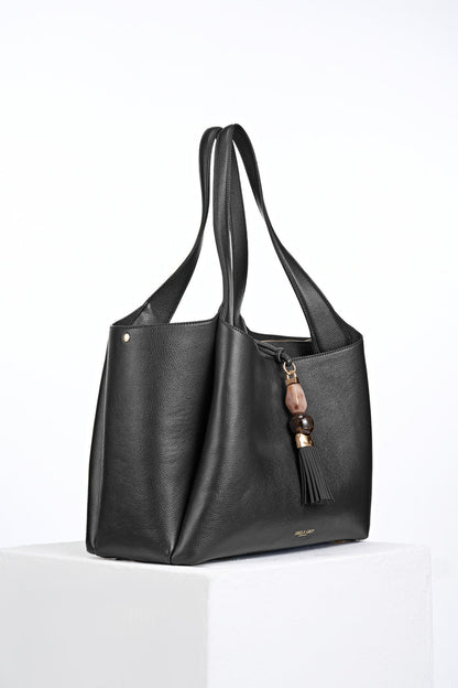 Side view of Stella Black faux leather Laptop Tote with Mayfair Tassel Closure detail