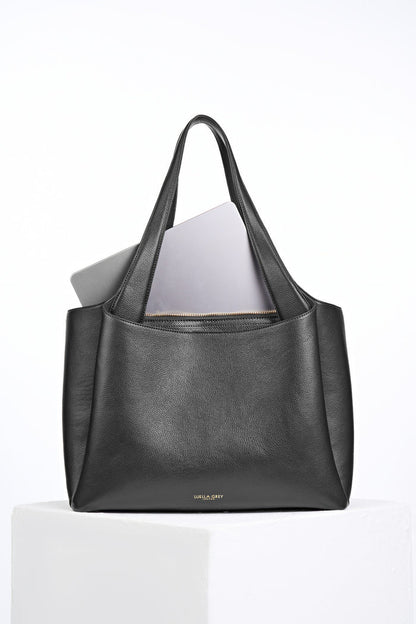 Back of Stella Black faux leather Laptop Tote with laptop in the removable central zipper laptop compartment