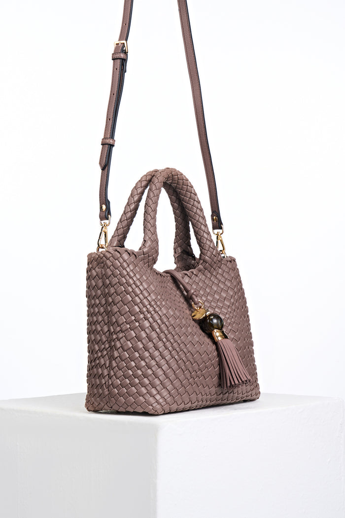 Side view of Suky Fawn faux leather Woven Crossbody with detachable crossbody strap attached to gold rings on the bag's side