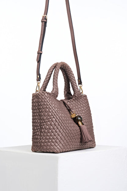 Side view of Suky Fawn faux leather Woven Crossbody with detachable crossbody strap attached to gold rings on the bag's side