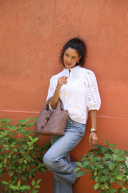 Female model wearing Suky Fawn faux leather Woven Crossbody over her arm using the grab handles