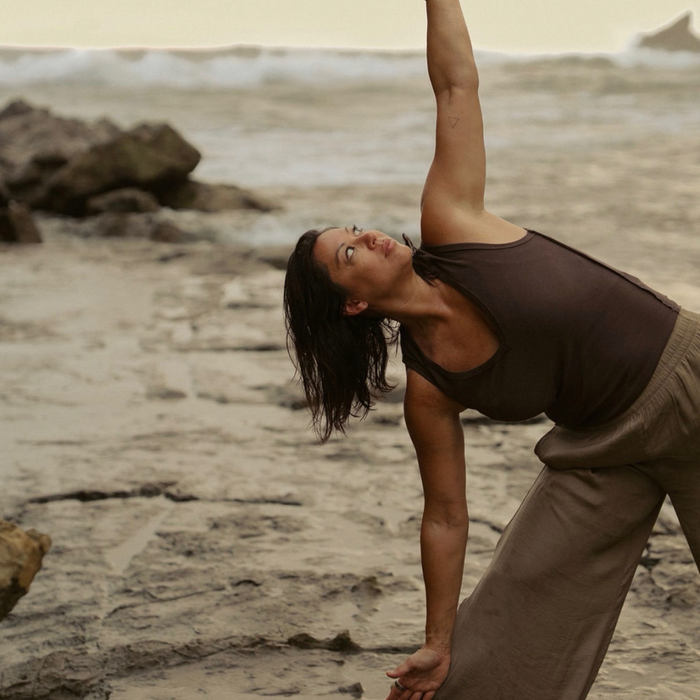 a woman stretching on a beach