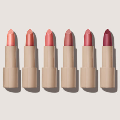 No Makeup Makeup – Six Creme Classic Lipsticks with different shades of pink on a light beige background, natural minimal makeup