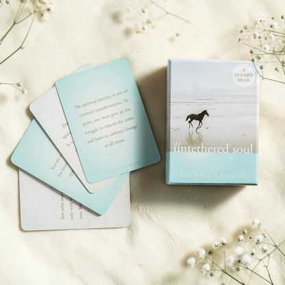 The untethered soul card deck with cards spread out on a light surface.