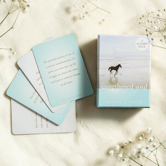 The untethered soul card deck with cards spread out on a light surface.