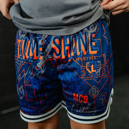 Blue shorts with orange text and graphics on a dark background