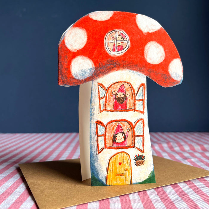 Toadstool-themed greeting card with red white-spotted mushroom top and house door illustration