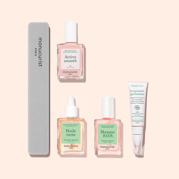 Five products from Manucurist’s Basic Routine – Ridged Nails are displayed on a light pink background, featuring essential nail care: a gray nail file for smoothing ridged nails, two dropper bottles labeled Active Smooth and Huile Verte (a nourishing cuticle oil), a pump bottle of Masque S.O.S., and a white tube of Concentré perfecteur.