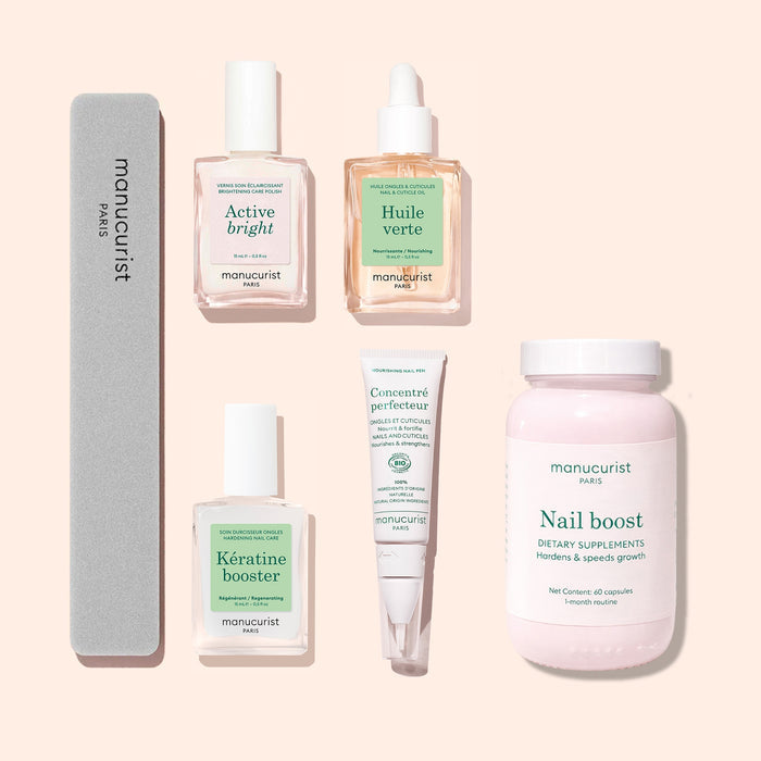 The Manucurist Ultimate Routine - Yellow Nails set features five expertly arranged nail care essentials—including files, serums, supplements, and creams—on a pale backdrop, ideal for strengthening and brightening your nails.