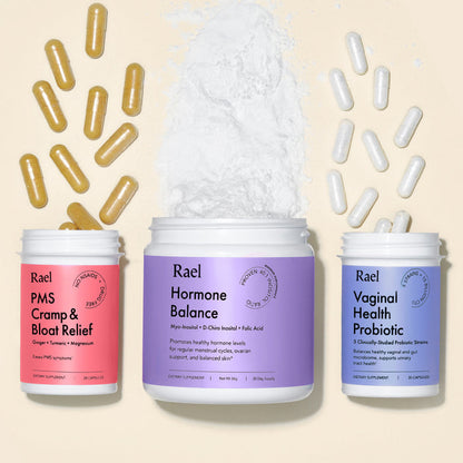 Three supplement jars labeled PMS Cramp & Bloat Relief, Hormone Balance, and Vaginal Health Probiotic by Rael, opened with respective capsules and powdered formula coming out.