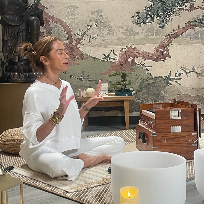 Woman in white practicing Yin yoga beside a sound bath bowl and candle with stacked bangle bracelets in a serene room by BuDhaGirl