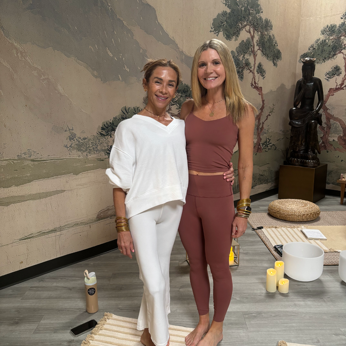 two women standing together in a room