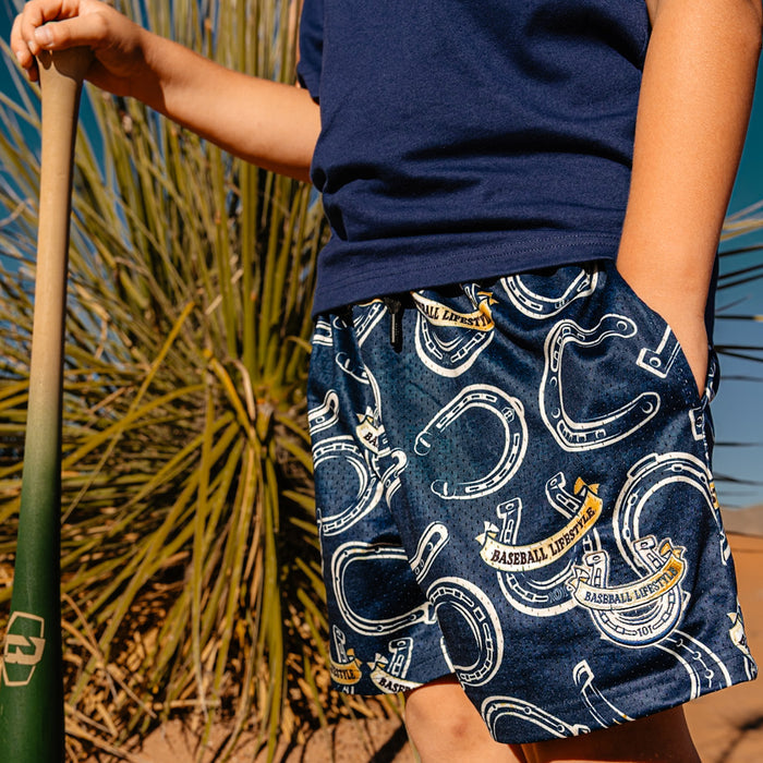 Person wearing navy shorts with horse shoe pattern and 'Baseball Lifestyle' text
