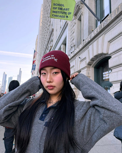 Person wearing a maroon beanie in front of the School of the Art Institute of Chicago