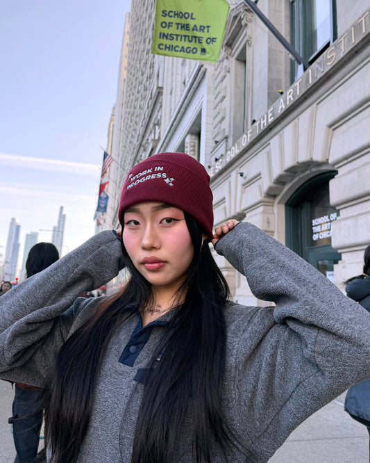 Person wearing a maroon beanie in front of the School of the Art Institute of Chicago