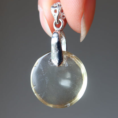 hand holding yellow quartz pendant